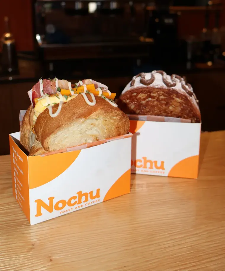 Dos toasts de Nochu en sus cajas sobre la barra